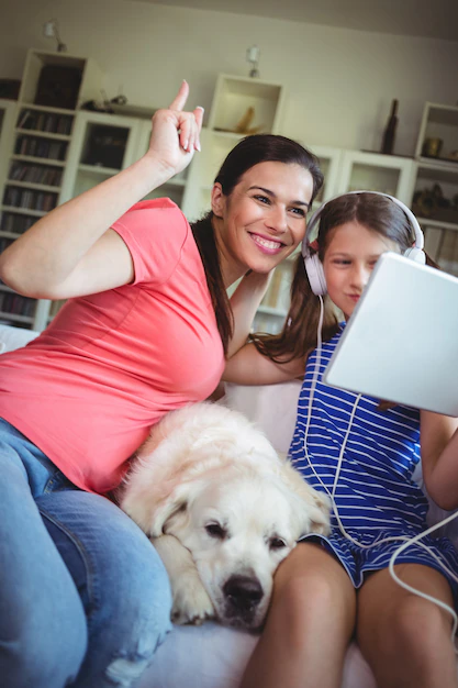 happy-mother-daughter-sitting-with-pet-dog-using-digital_107420-39199